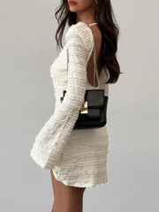 Model wearing pale apricot textured flare sleeve bodycon mini dress, side view showing open back