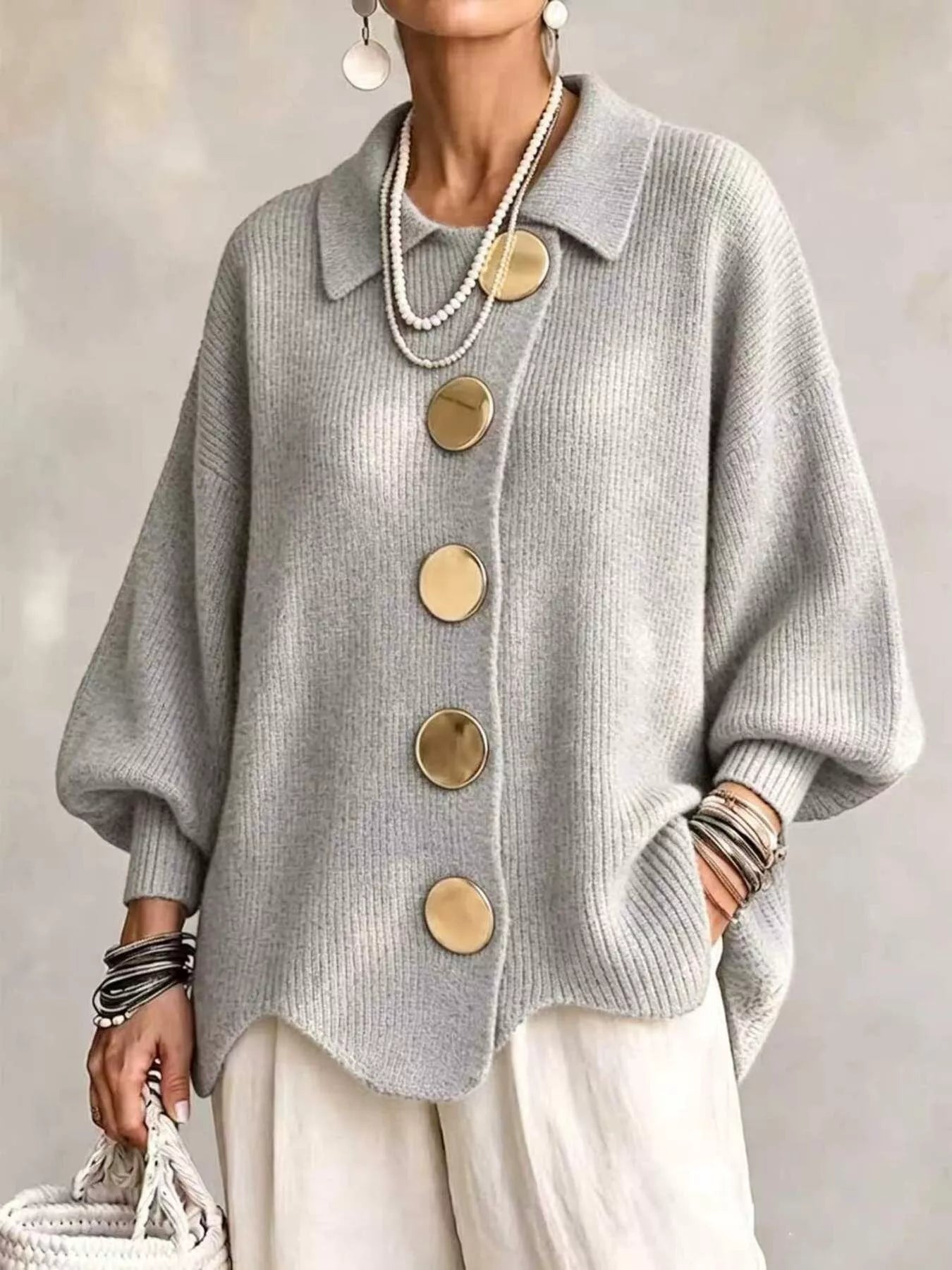 Front view of a light gray knit cardigan with large gold buttons