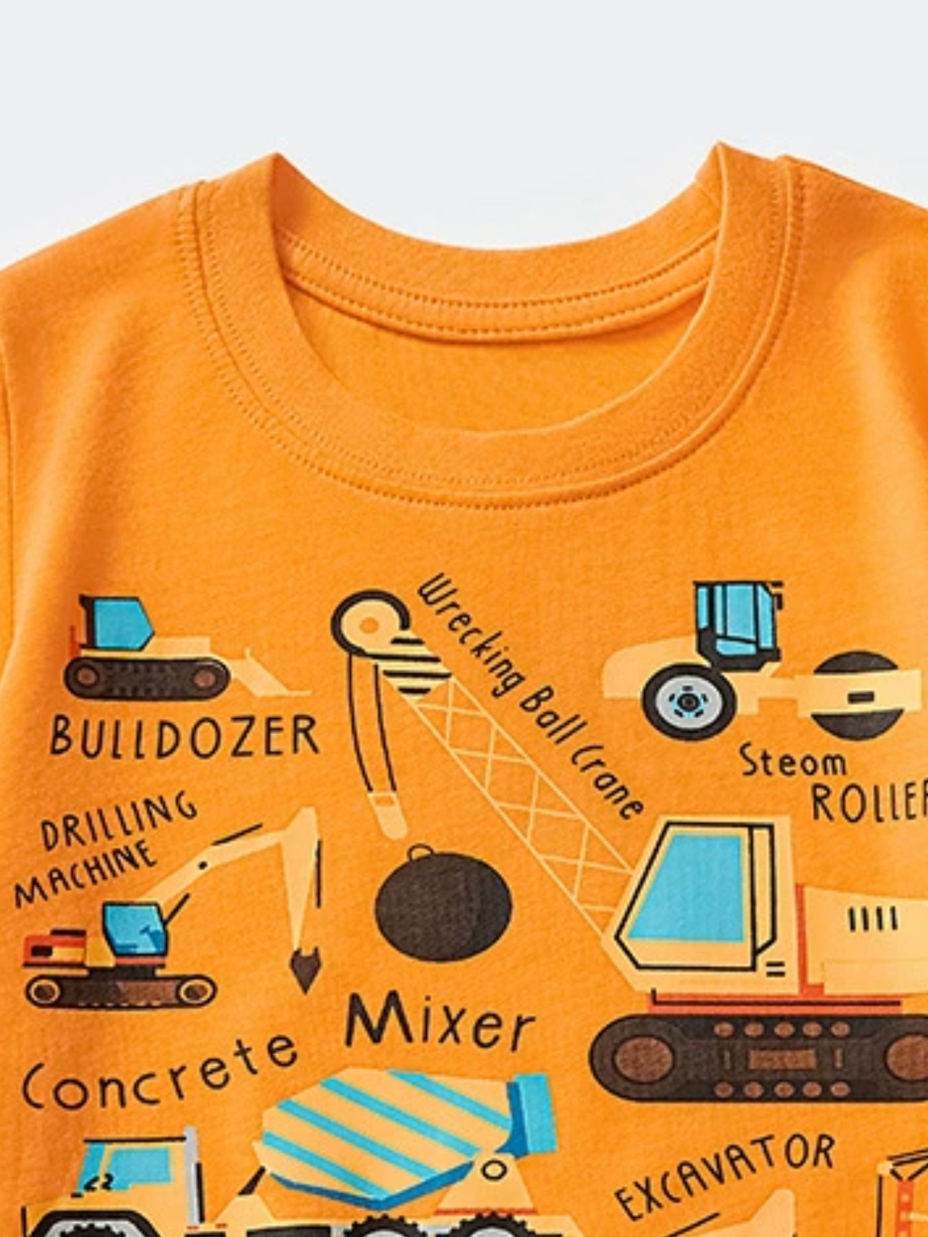 Close-up of the tangerine crew neckline and bulldozer and crane graphics on a children's T-shirt