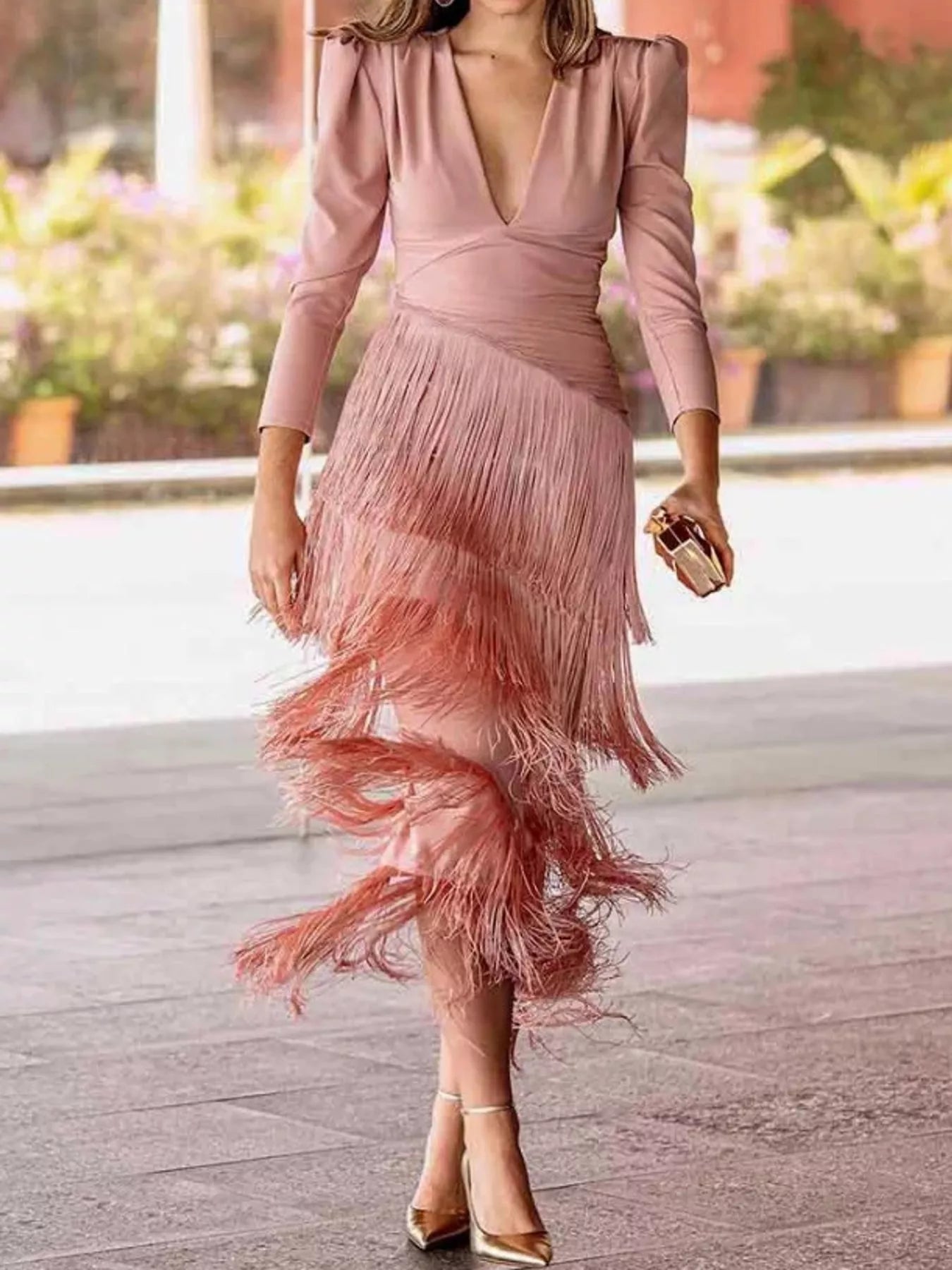 Full length view of a pink fringed maxi dress with puff sleeves worn walking outdoors