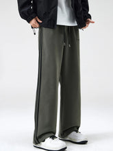 Men's army green relaxed-fit pants with side stripes, a drawstring waist and pockets.