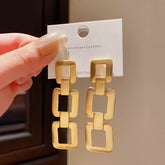 Contemporary Gold Tone Drop Earrings with Interlocking Geometric Links