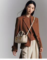 Small Off-White Top Handle Bag with Unique Gold Tone Hand Sculptures