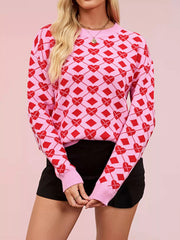 On-model front view of a pink knit sweater with red heart and diamond argyle pattern