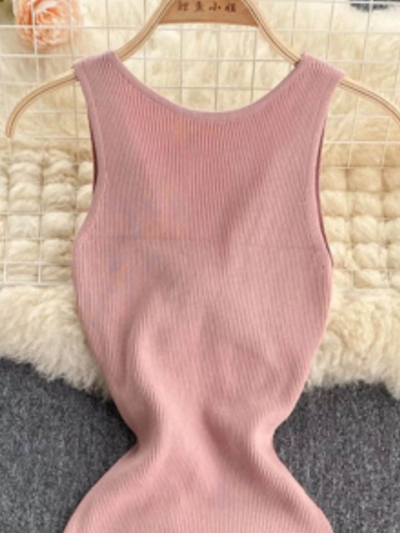 Close front view of pink ribbed knit bodice with scoop neckline on hanger