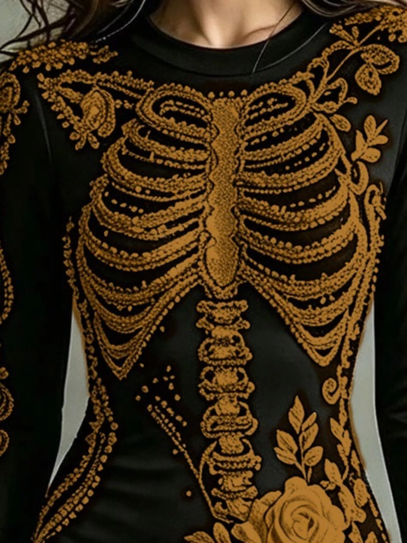 Close detail of gold skeleton print on black long sleeve bodycon dress bodice