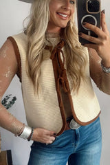 On-model mirror selfie of a beige tie front sweater vest with brown contrast trim