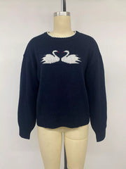 Front view on a mannequin of a navy sweater with white swan pair motif