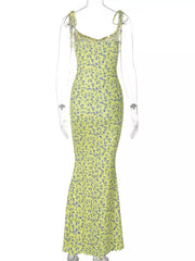 Back view of clear mannequin wearing yellow floral print bodycon maxi dress with tie straps
