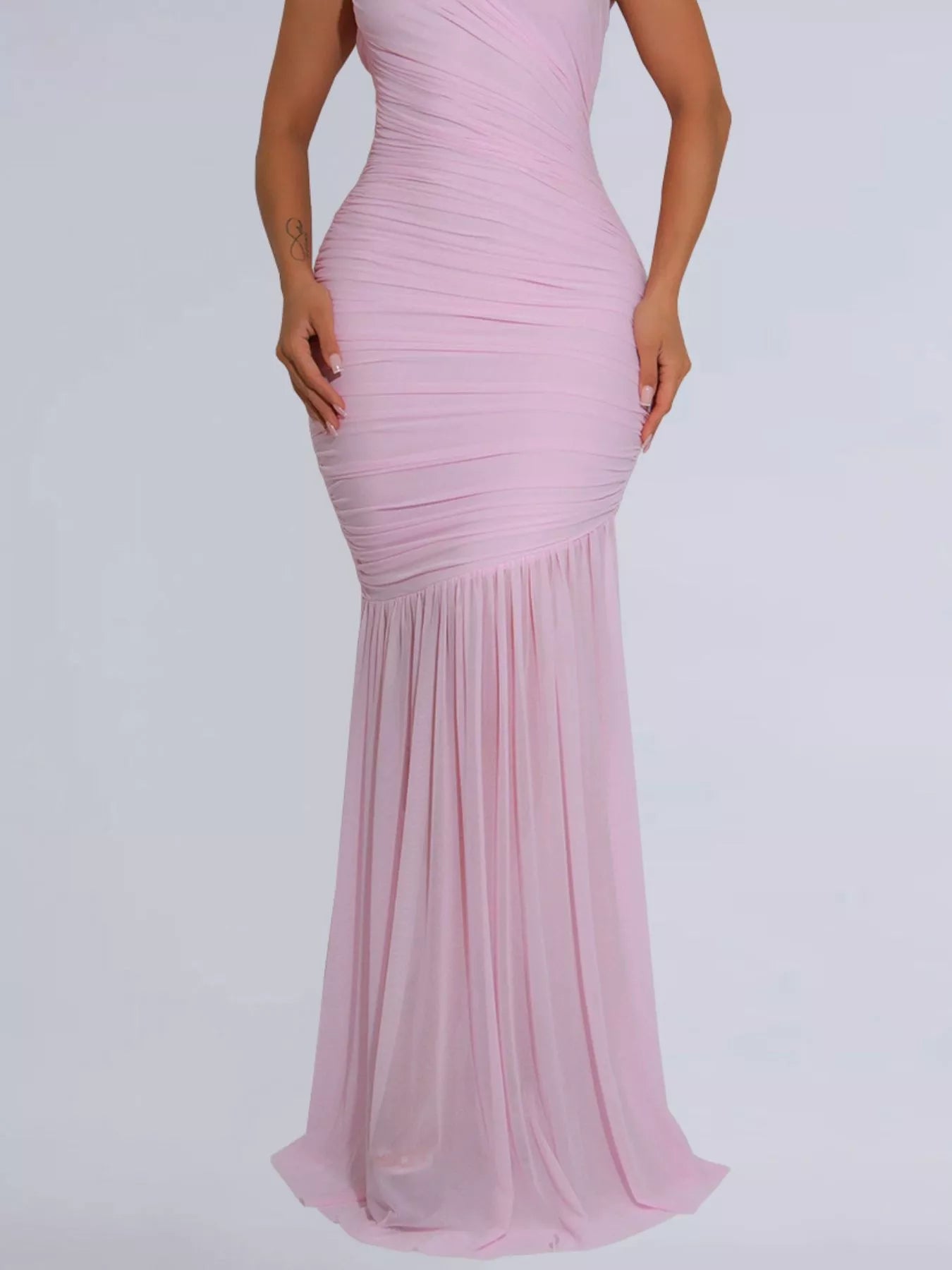 Lower view of blush pink ruched bodycon maxi dress showing the flowing skirt