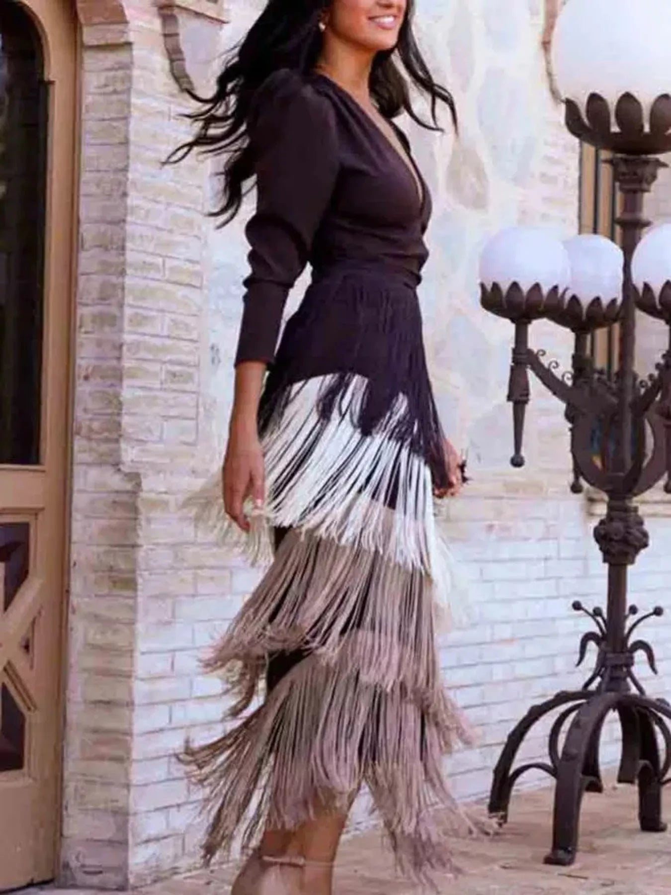 Side view of a coffee brown fringed maxi dress with layered fringe worn outdoors