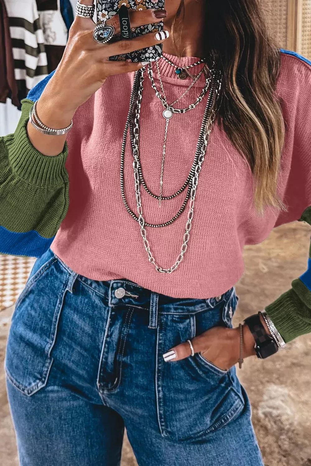 Close mirror view of the dusty pink sweater and its green striped sleeve