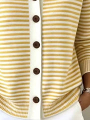 Close-up of the lower front and ribbed hem of a yellow and white striped knit cardigan