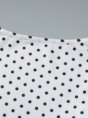 Close-up detail of a white polka dot top showing the ruched V-neckline and upper front.