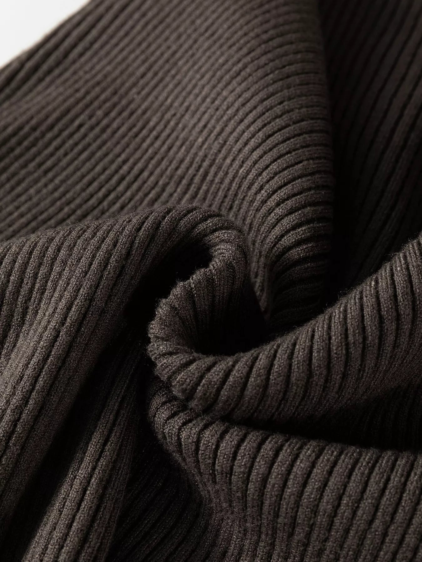 Close up of folded coffee brown ribbed knit fabric on sweater vest