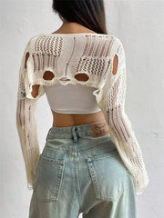 Back view of cream distressed cropped knit cover up with openwork and cutouts.