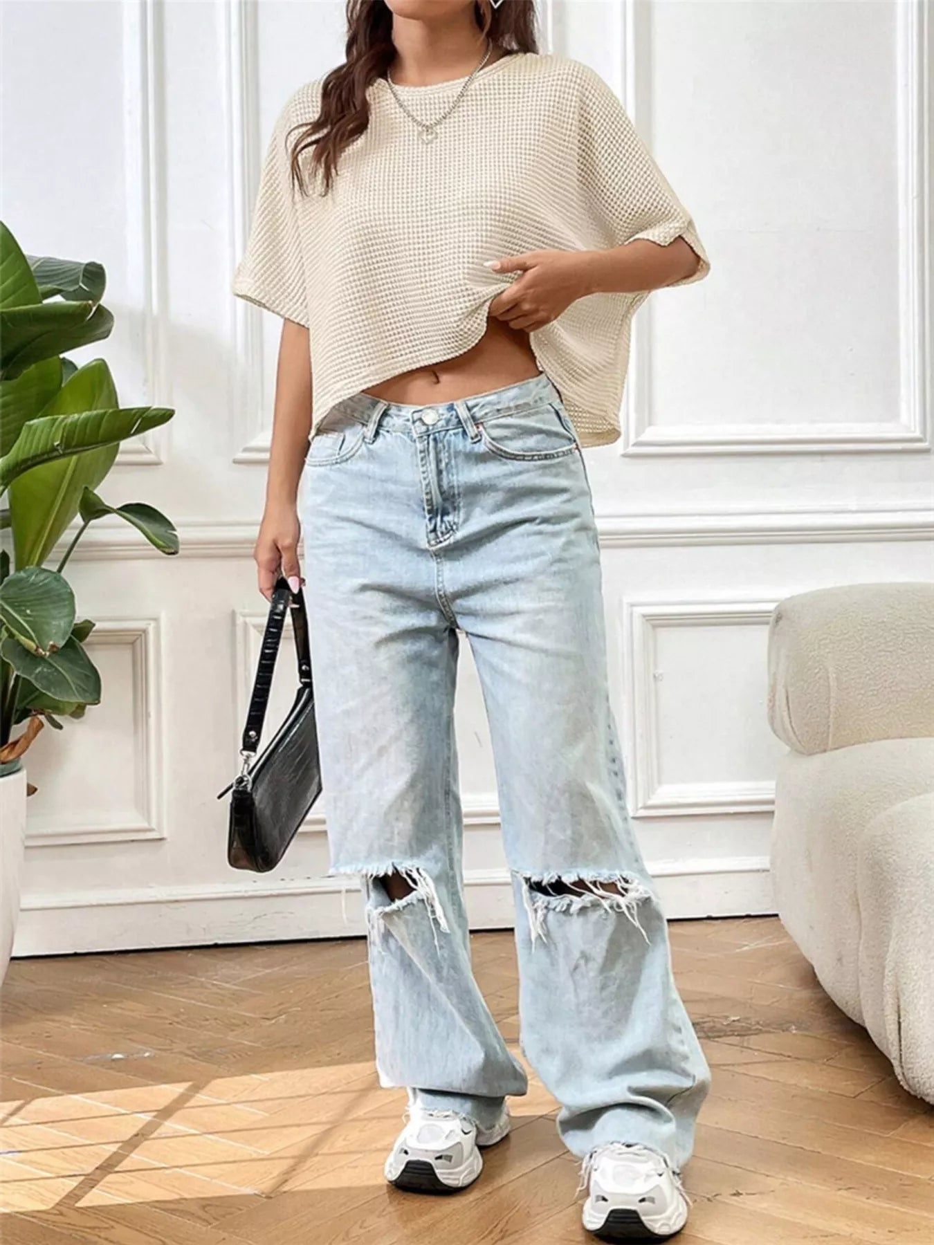 Woman wearing a cream waffle-knit cropped T-shirt with short sleeves and a relaxed fit.
