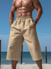 Men's light khaki cropped casual pants with a drawstring waist and pockets.