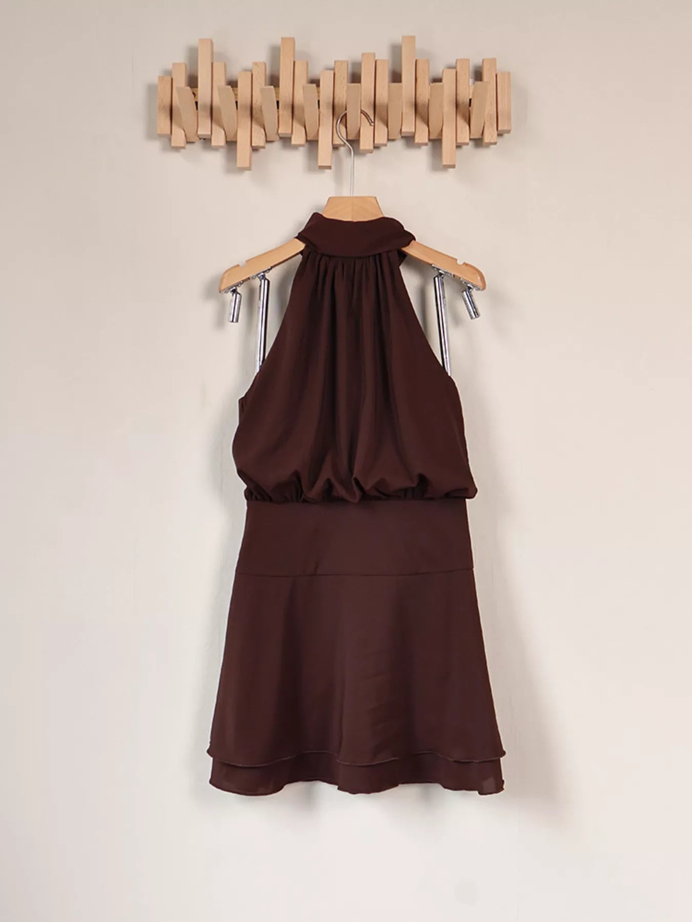 Brown halter mini dress hanging on wooden hanger, full front view