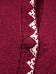Extreme close view of the burgundy cardigan button and cream zigzag trim