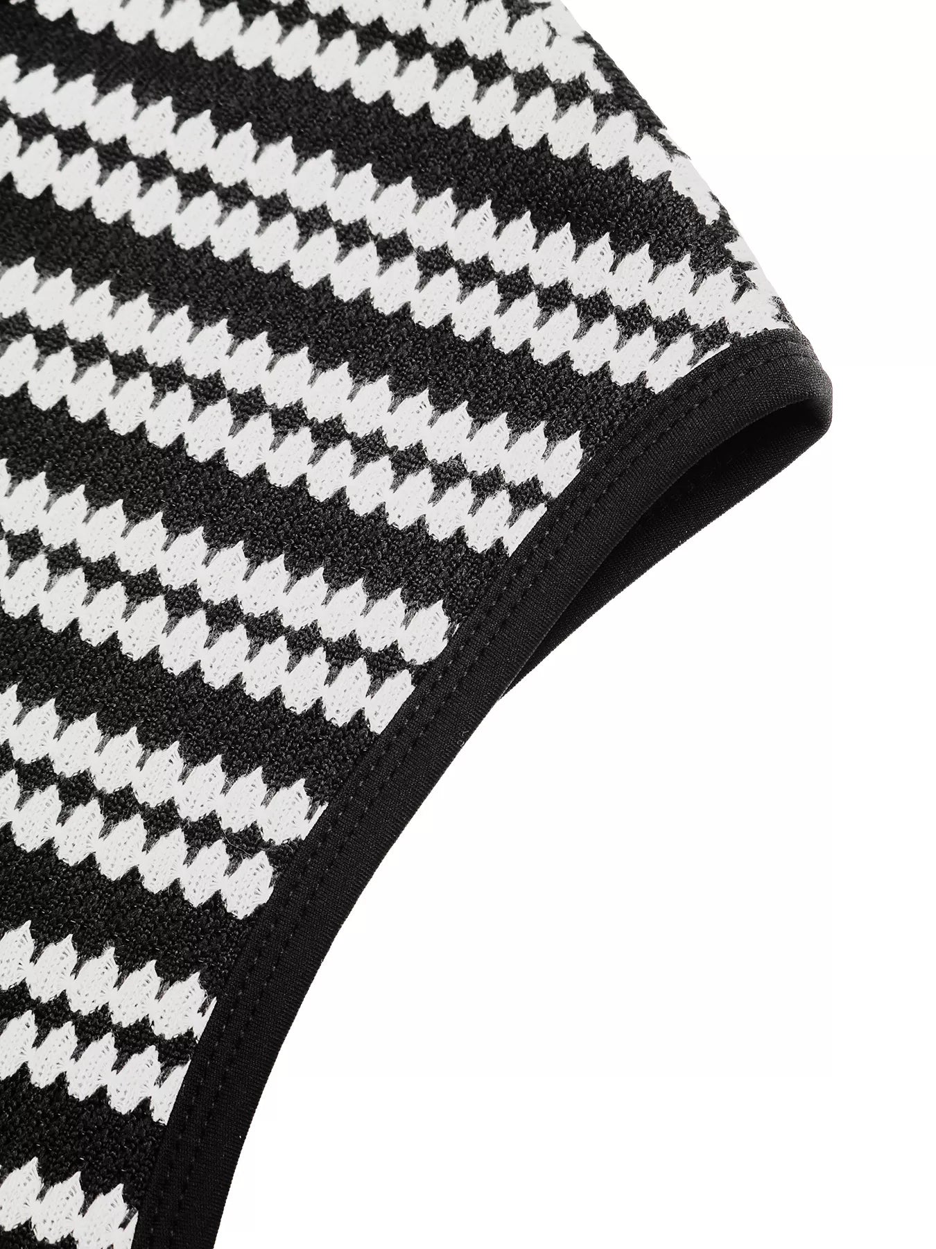 Close up flat detail of a black and white striped knit dress armhole trim
