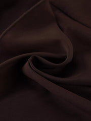 Close detail of brown mini dress fabric folded to show smooth texture