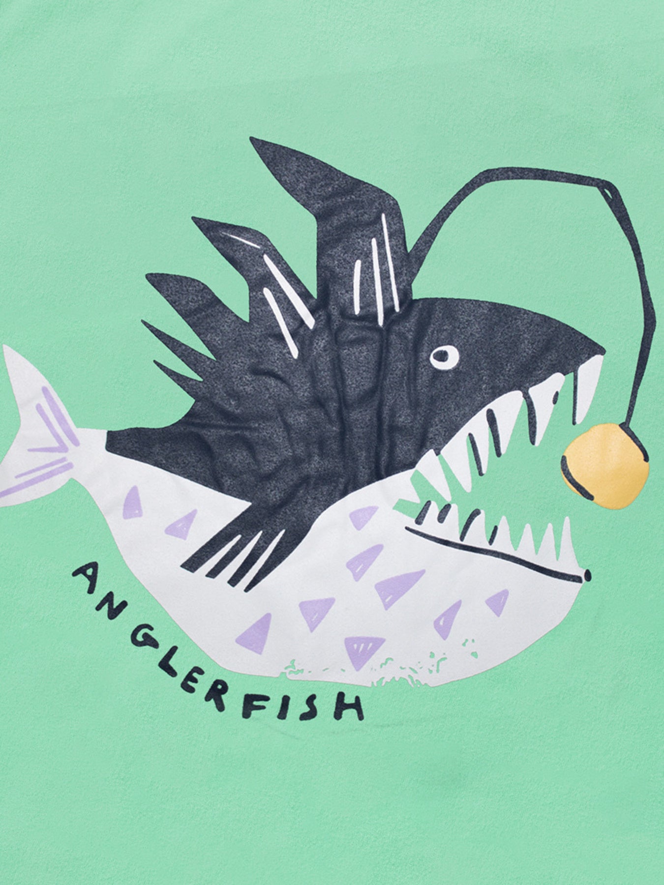 Close-up detail of the anglerfish graphic with sharp teeth and glowing yellow lure