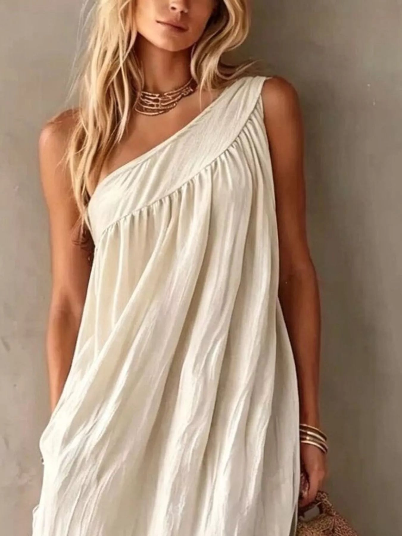 Close view of a white one shoulder maxi dress showing the gathered bodice and neckline