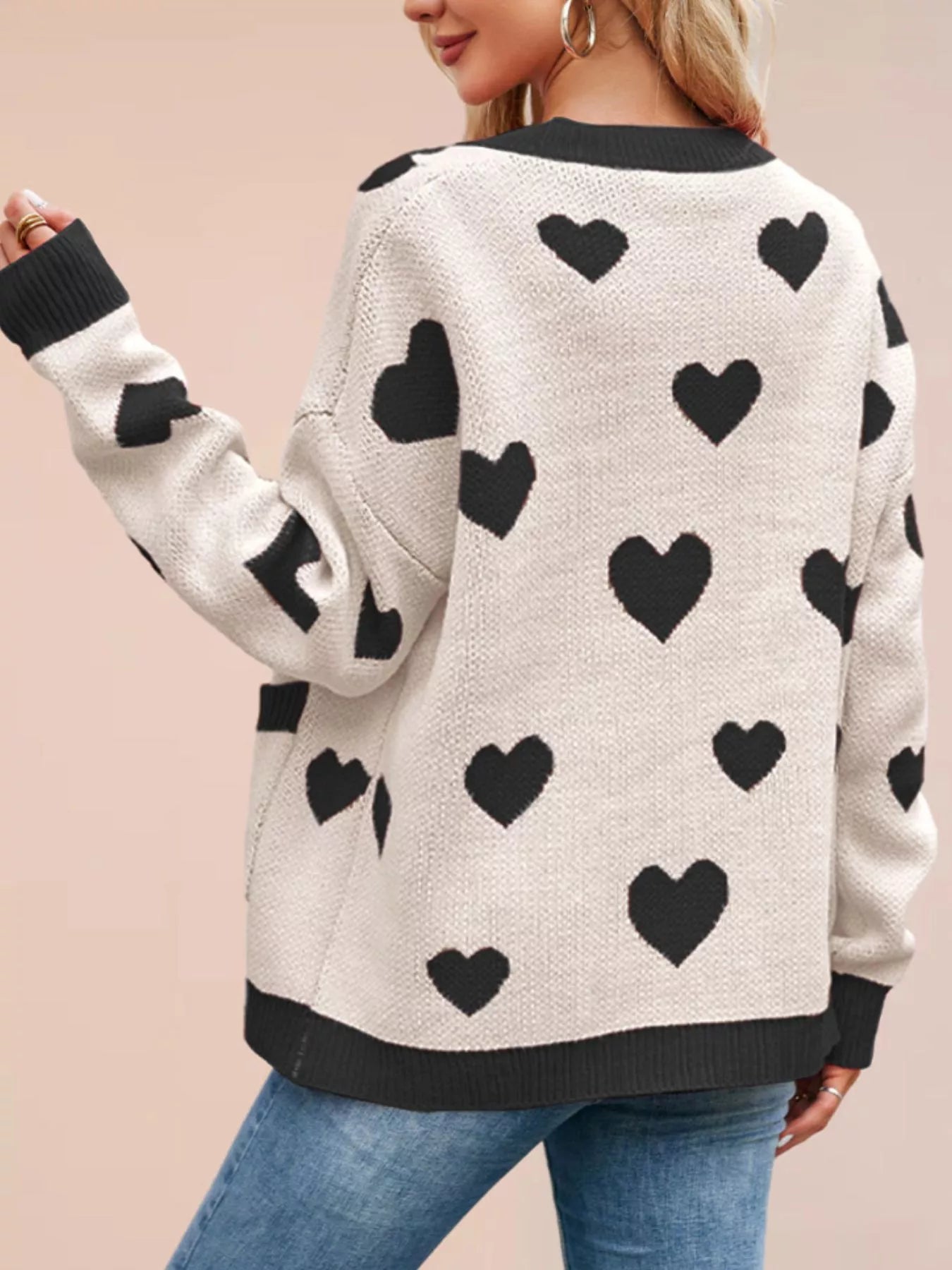 Back view of the cream knit cardigan with black hearts and black trim