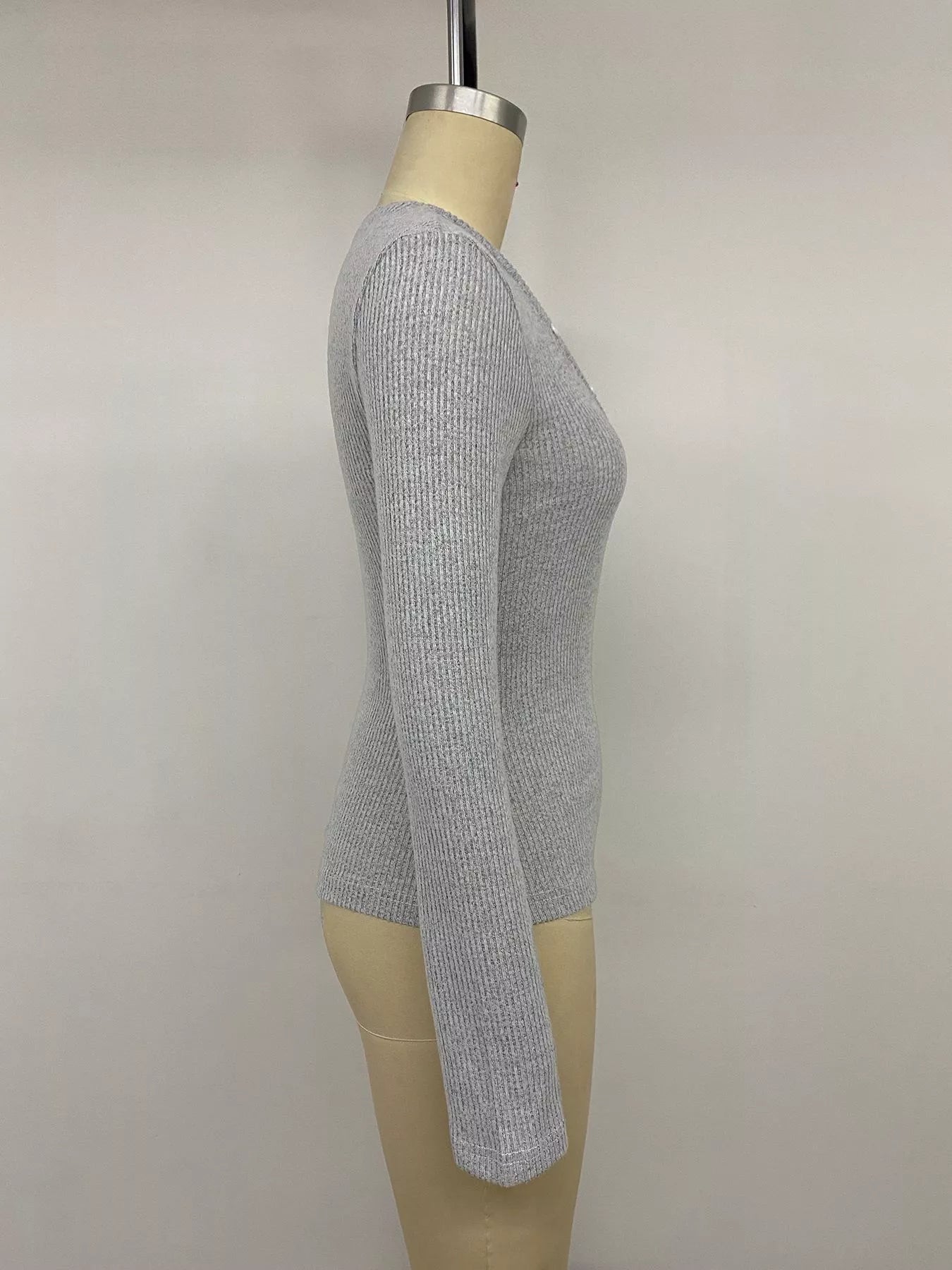 Side view of a gray ribbed long-sleeve Henley T-shirt with a fitted silhouette.