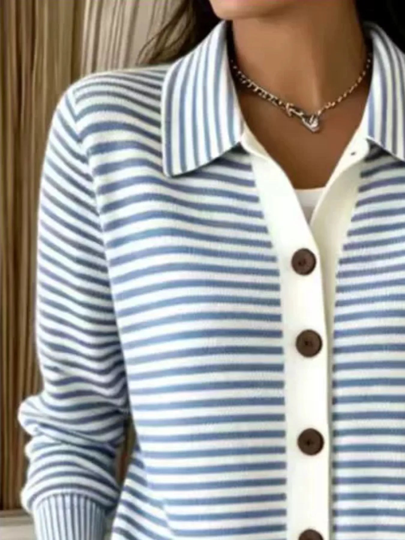 Close-up on-model view of sky blue and white striped collared cardigan with brown buttons