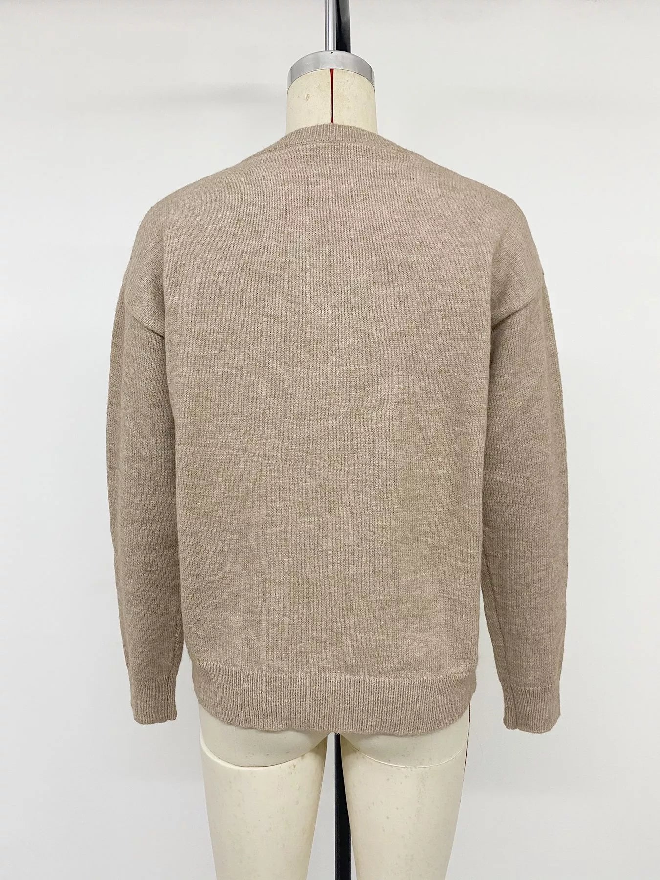 Back view of khaki dropped shoulder long sleeve sweater on mannequin with ribbed hem