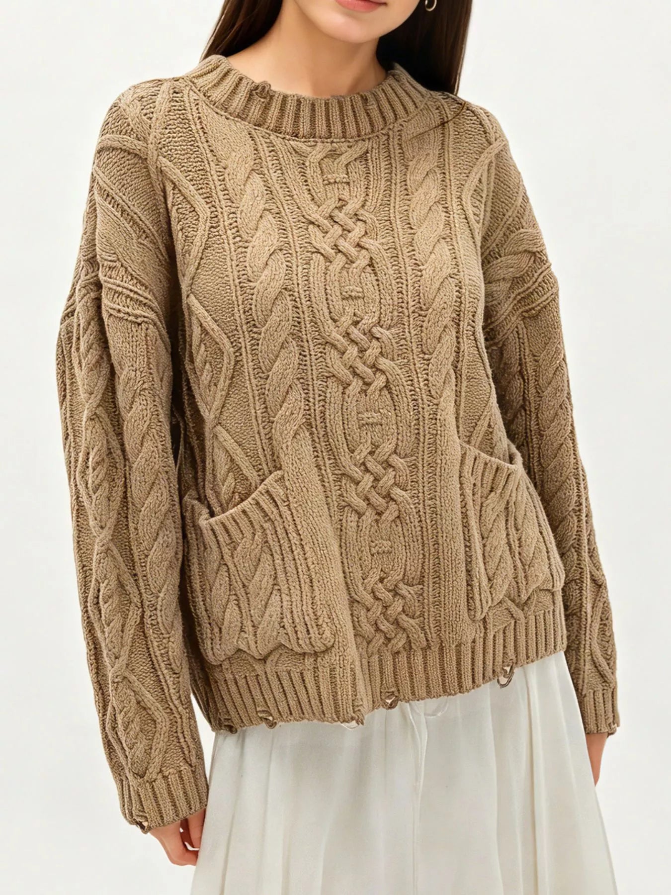 Front view of khaki cable knit sweater with front pockets and white skirt