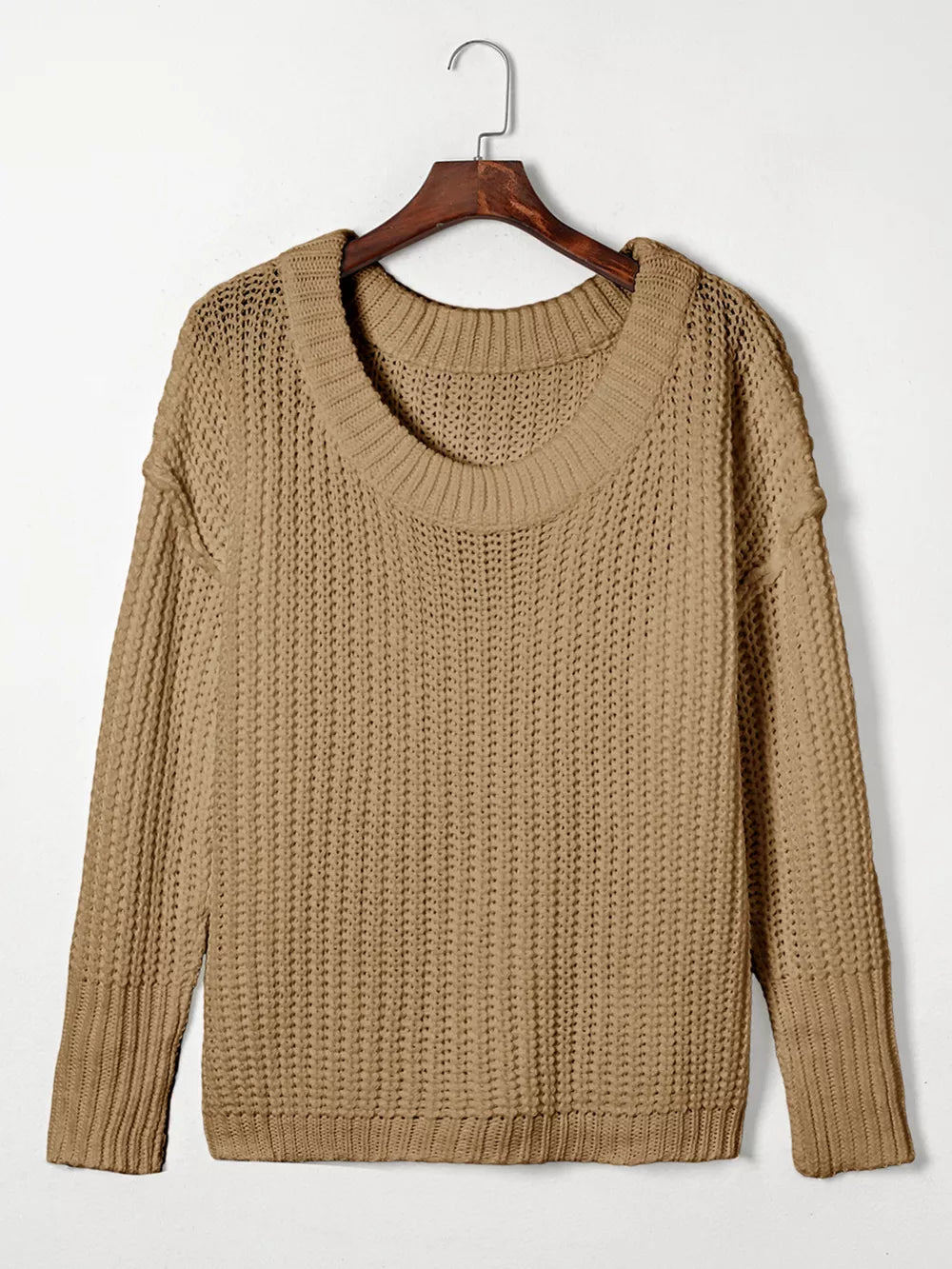 Taupe ribbed knit sweater with round neckline and long sleeves hanging on a wooden hanger.