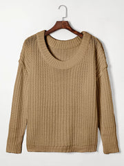 Taupe ribbed knit sweater with round neckline and long sleeves hanging on a wooden hanger.