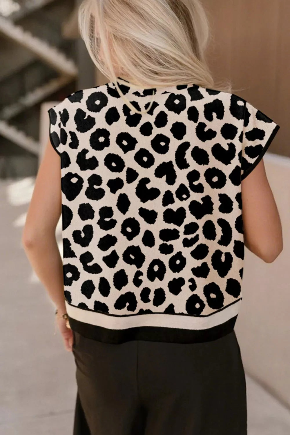 Back view of the black and cream leopard print high neck sweater with short sleeves and small spots.