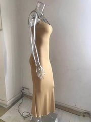 Side profile of a camel spaghetti strap bodycon maxi dress on a clear mannequin with a flared hem