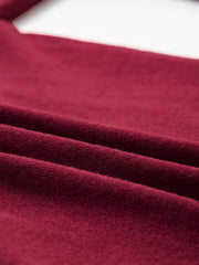 Close view of the folded burgundy knit fabric showing soft texture