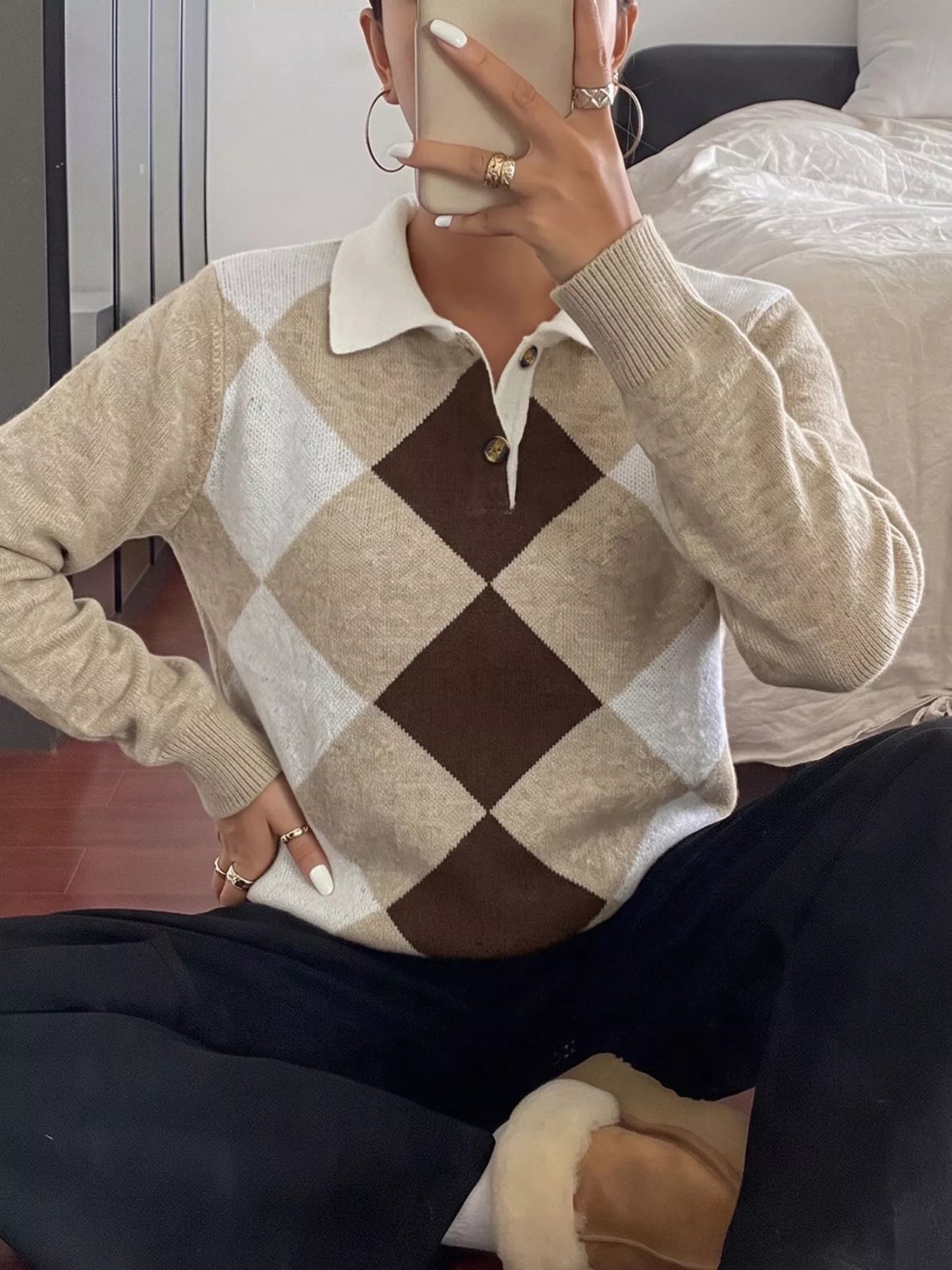 Seated mirror selfie front view of the beige, brown, and white argyle polo sweater