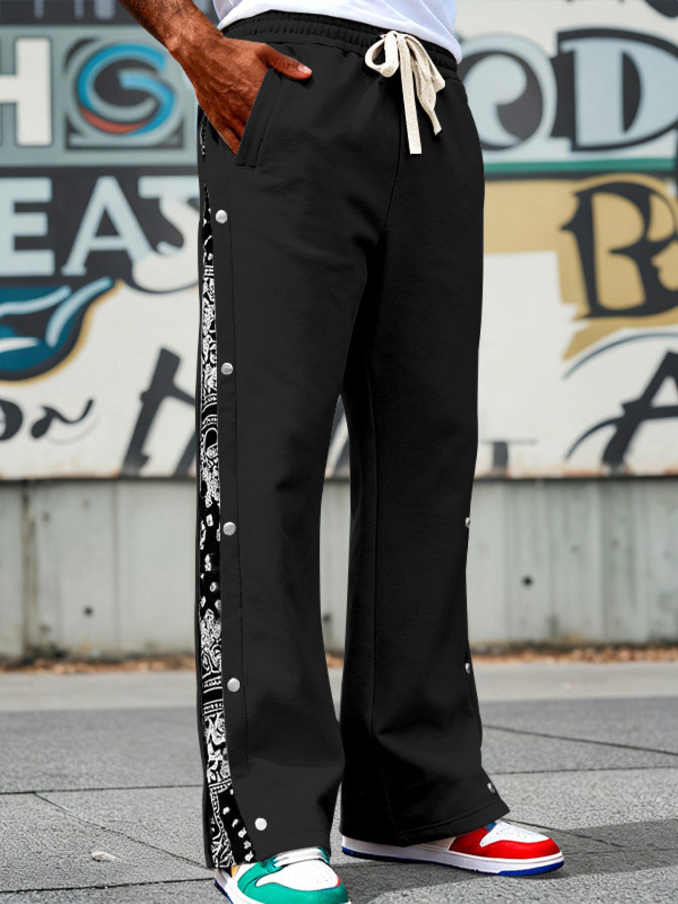 Men's black wide-leg pants with side snaps and a drawstring waist.