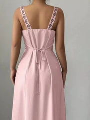 Close back view of dusty pink maxi dress showing tied waist and patterned straps