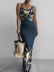 Navy blue sleeveless bodycon maxi dress with cream leaf print worn front facing