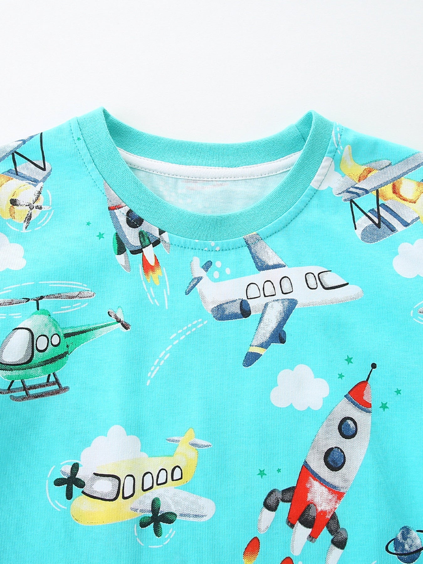 Close-up of the aqua crew neckline with ribbed trim and airplane rocket and helicopter prints below