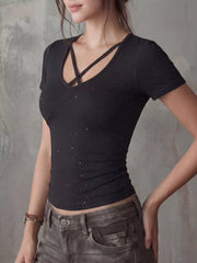 Close-up front view of a black fitted short-sleeve T-shirt with crossover neckline and speckled pattern.