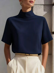 Navy mock neck short-sleeve T-shirt worn with cream trousers and a