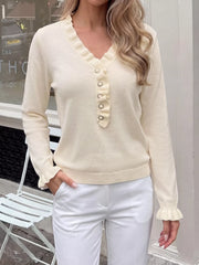 Front view of cream ruffle trim V neck knit top with white pants outdoors