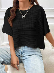 Black waffle-knit cropped T-shirt with short sleeves, shown styled with light-wash jeans and a heart pendant necklace
