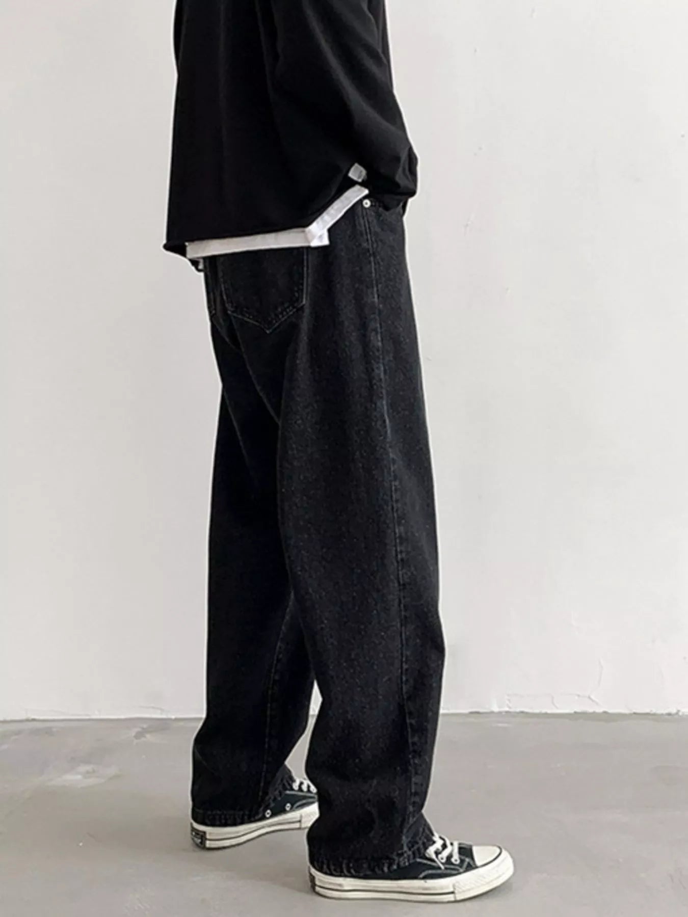 Men's Black loose fit wash jeans on model, back view showing rear pocket.