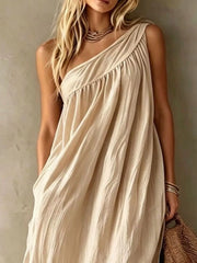 Close view of a beige one shoulder maxi dress showing the gathered bodice and neckline