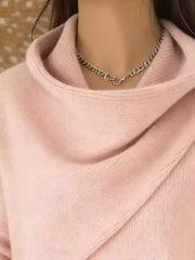 Close-up of the pale pink cowl neckline showing the draped asymmetric collar and fine knit texture